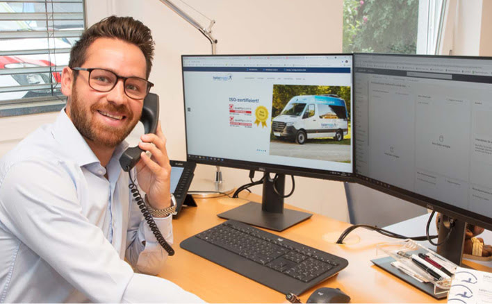 Ein freundlicher Mitarbeiter von hallermobil beantwortet in seinem Büro einen Anruf.